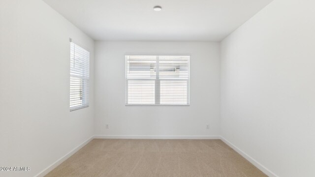 7384 W Buckhorn Trl, Peoria, AZ 85383 - unfurnished room with plenty of natural light, baseboards, and light carpet
