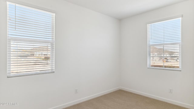 7384 W Buckhorn Trl, Peoria, AZ 85383 - empty room with light colored carpet, baseboards, and plenty of natural light