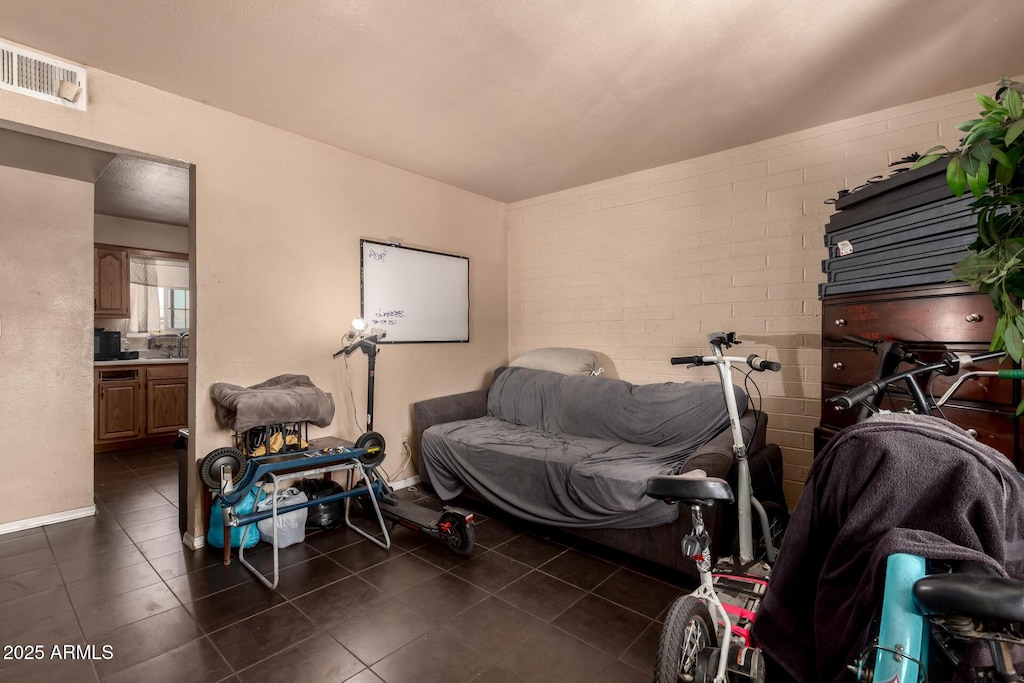 interior space featuring dark tile patterned floors, visible vents, and baseboards