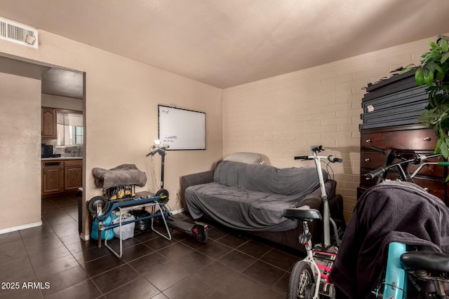 interior space featuring dark tile patterned floors, visible vents, and baseboards