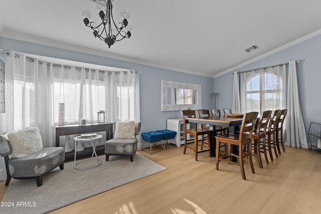 dining room with a notable chandelier, light wood-type flooring, crown molding, and vaulted ceiling