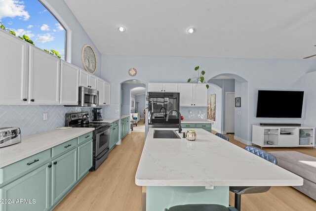 15912 W Central St, Surprise, AZ 85374 - kitchen featuring stainless steel appliances, arched walkways, a sink, open floor plan, and green cabinetry