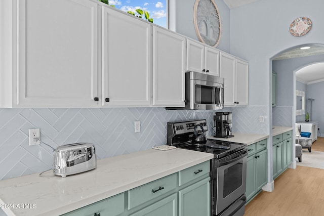 15912 W Central St, Surprise, AZ 85374 - kitchen featuring appliances with stainless steel finishes, green cabinetry, arched walkways, light wood finished floors, and white cabinetry