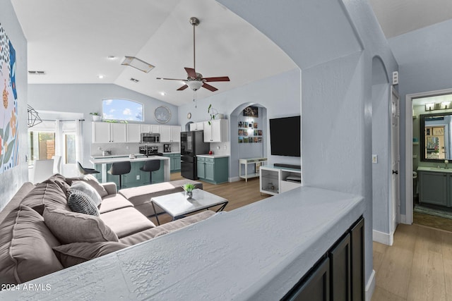 15912 W Central St, Surprise, AZ 85374 - living area featuring arched walkways, a ceiling fan, light wood-style floors, high vaulted ceiling, and baseboards
