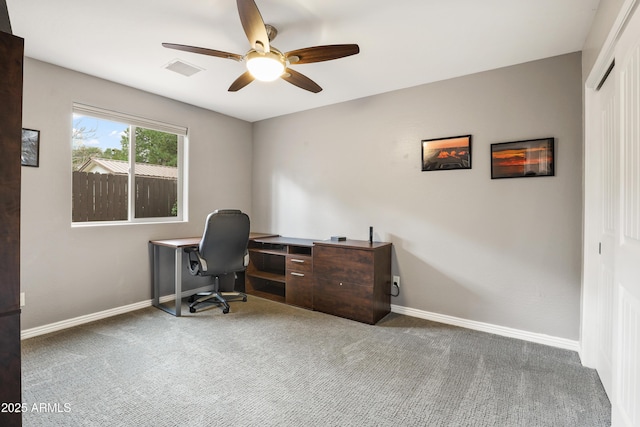 carpeted home office featuring visible vents, baseboards, and a ceiling fan