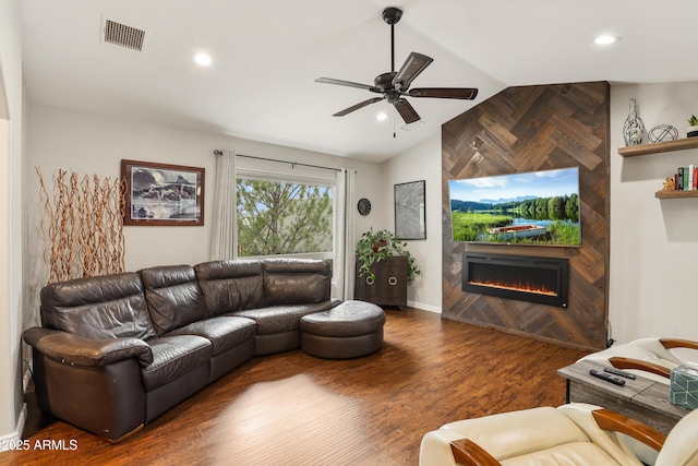 living room with visible vents, ceiling fan, wood finished floors, vaulted ceiling, and a fireplace