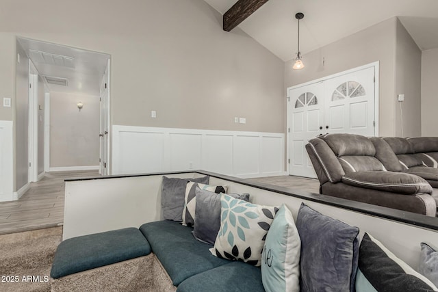 3061 W Betty Elyse Ln, Phoenix, AZ 85053 - living area with beamed ceiling, light wood-style flooring, wainscoting, and high vaulted ceiling