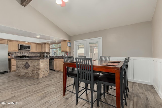 3061 W Betty Elyse Ln, Phoenix, AZ 85053 - dining room featuring french doors, light wood-style flooring, high vaulted ceiling, and wainscoting