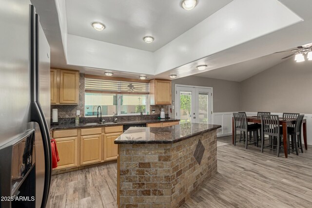 3061 W Betty Elyse Ln, Phoenix, AZ 85053 - kitchen featuring stainless steel fridge, a ceiling fan, french doors, light wood-type flooring, and decorative backsplash