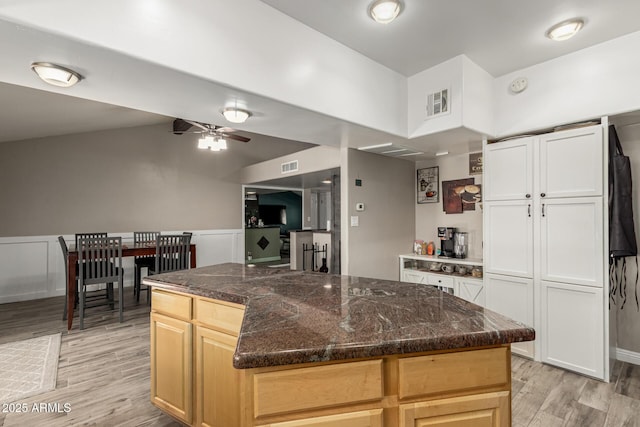 3061 W Betty Elyse Ln, Phoenix, AZ 85053 - kitchen featuring light wood-style flooring, a ceiling fan, dark stone counters, a kitchen island, and lofted ceiling