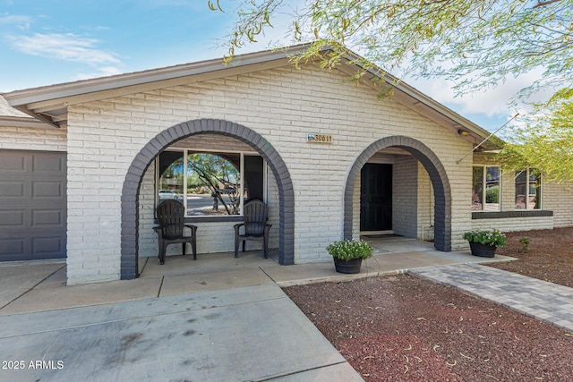 3061 W Betty Elyse Ln, Phoenix, AZ 85053 - view of front of home featuring brick siding, covered porch, and an attached garage