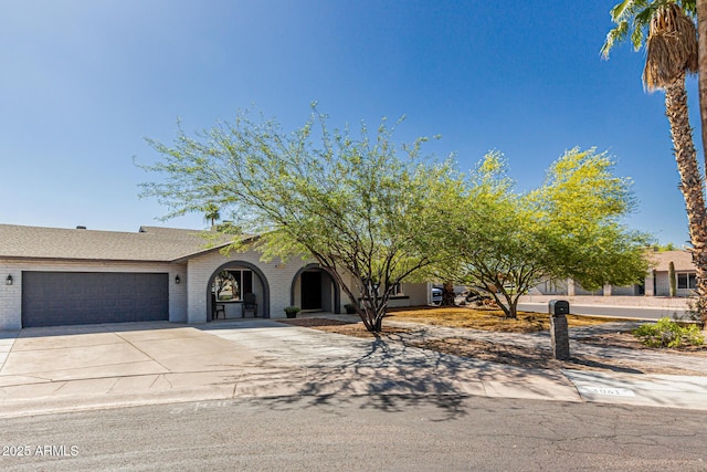 3061 W Betty Elyse Ln, Phoenix, AZ 85053 - view of front facade with a garage, concrete driveway, and brick siding