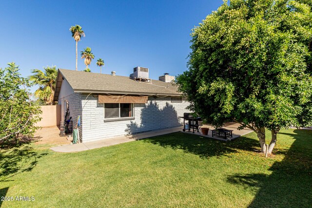 3061 W Betty Elyse Ln, Phoenix, AZ 85053 - rear view of house featuring brick siding, a patio area, and roof with shingles