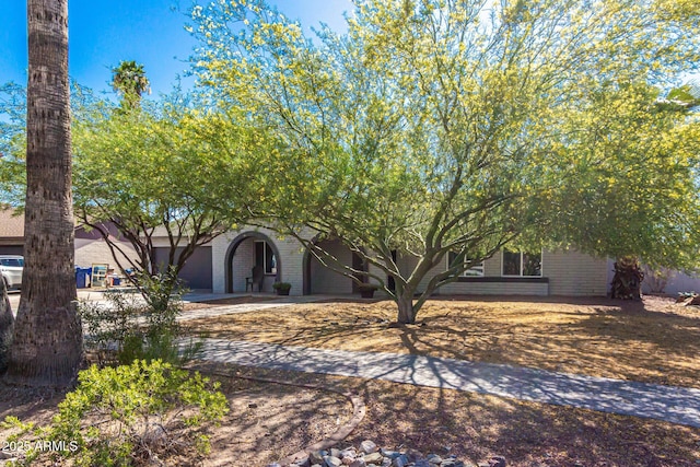 3061 W Betty Elyse Ln, Phoenix, AZ 85053 - obstructed view of property with brick siding, an attached garage, and driveway