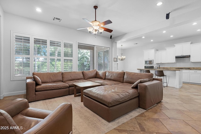 living room featuring baseboards, ceiling fan with notable chandelier, recessed lighting, and visible vents