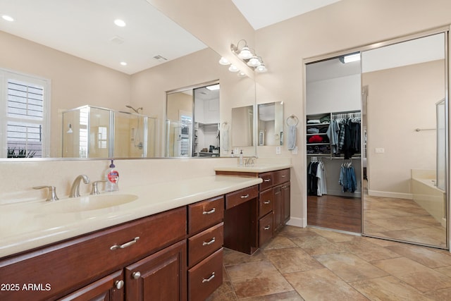 bathroom featuring vanity, visible vents, a bathtub, a spacious closet, and a shower stall