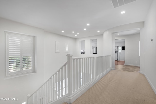 corridor featuring visible vents, baseboards, an upstairs landing, carpet, and recessed lighting