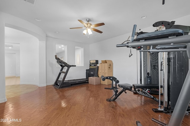 workout area featuring baseboards, a ceiling fan, wood finished floors, and visible vents