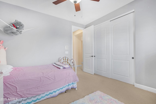 carpeted bedroom with a closet, a ceiling fan, and baseboards