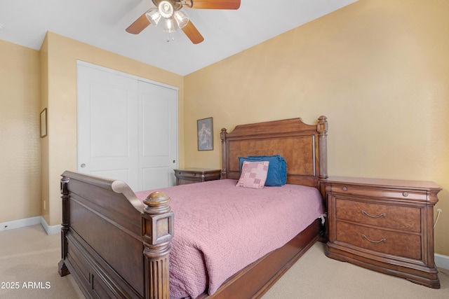 bedroom with a closet, a ceiling fan, baseboards, and light carpet
