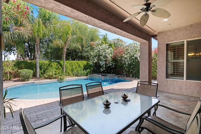 view of patio featuring ceiling fan and a pool with connected hot tub