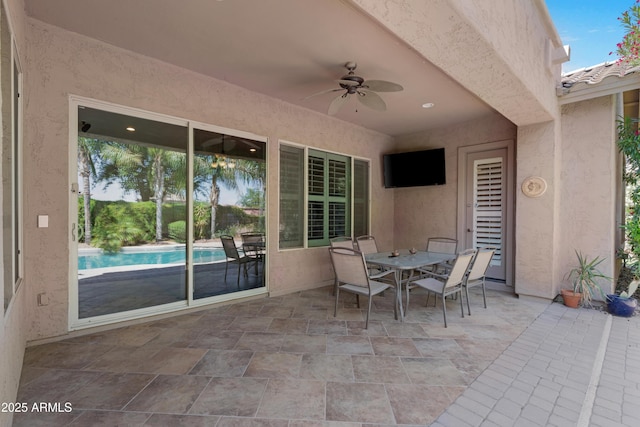 view of patio / terrace with ceiling fan, outdoor dining area, and an outdoor pool