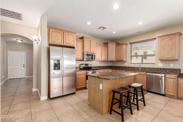 kitchen with visible vents, light brown cabinets, appliances with stainless steel finishes, and a kitchen island