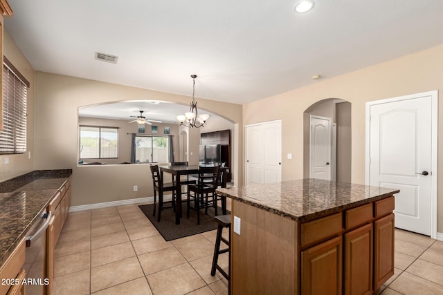 kitchen with ceiling fan with notable chandelier, light tile patterned flooring, arched walkways, visible vents, and dishwasher