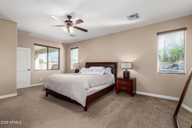 carpeted bedroom with baseboards, visible vents, and a ceiling fan
