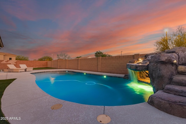 pool at dusk with a fenced backyard, a fenced in pool, and a patio area