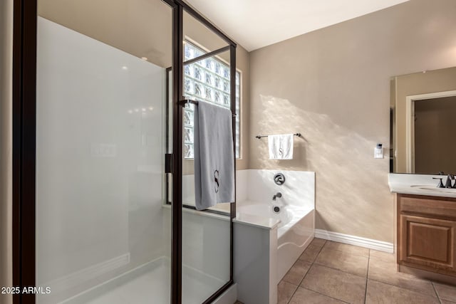 full bath with tile patterned flooring, vanity, baseboards, a stall shower, and a garden tub