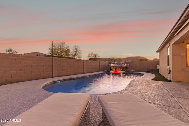 pool at dusk featuring a fenced backyard, a patio area, and a fenced in pool