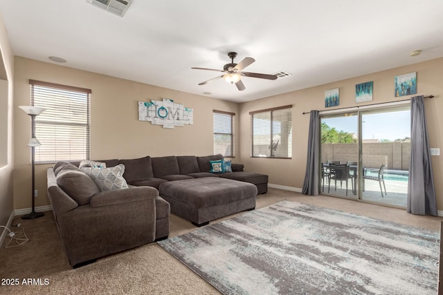 living area with baseboards, visible vents, carpet floors, and a ceiling fan
