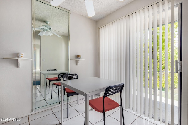 tiled dining room featuring a textured ceiling and ceiling fan