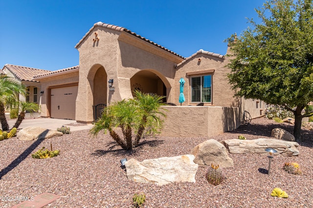 mediterranean / spanish-style home with a garage