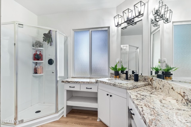full bath with wood finished floors, a stall shower, and vanity