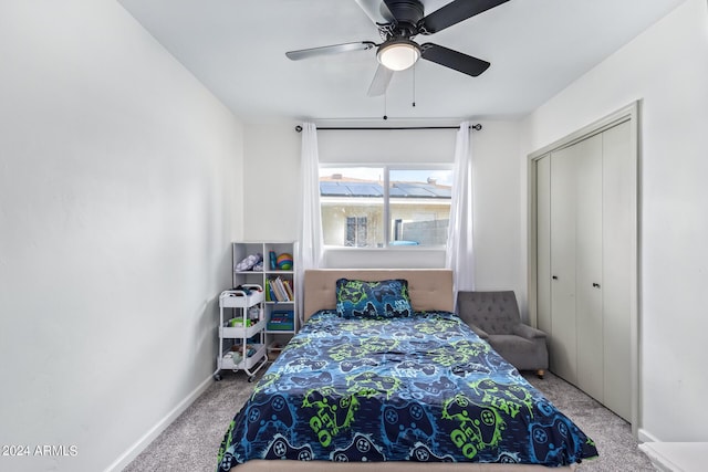 carpeted bedroom with a ceiling fan, a closet, and baseboards