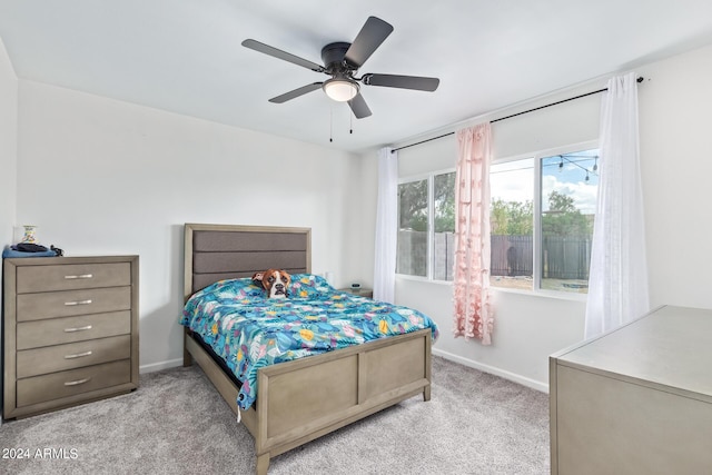 bedroom featuring baseboards, a ceiling fan, and light colored carpet