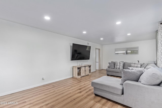 living room featuring baseboards, light wood-type flooring, and recessed lighting
