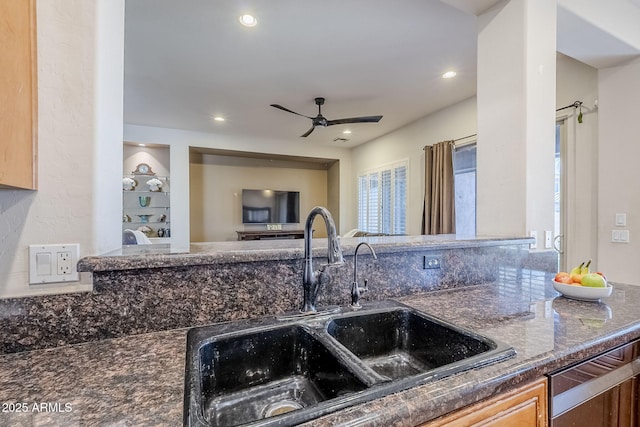 kitchen with ceiling fan, sink, and dark stone counters