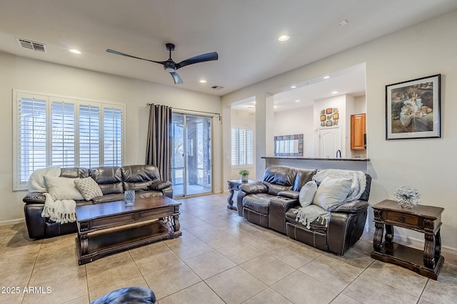 living room featuring light tile patterned floors and ceiling fan