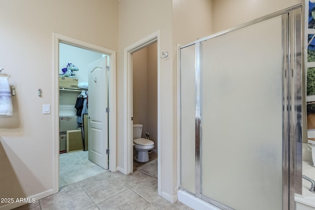 bathroom featuring tile patterned flooring, toilet, and an enclosed shower