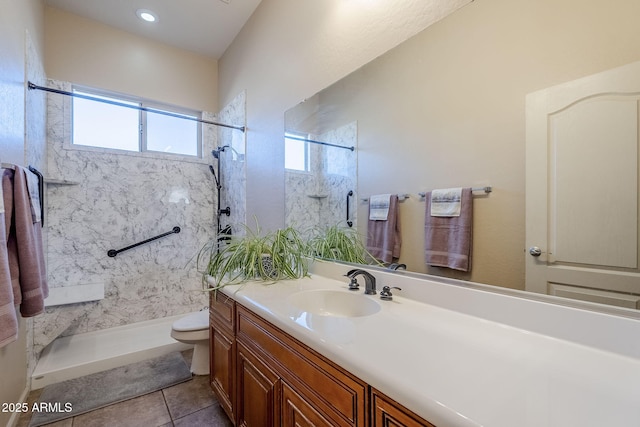 bathroom featuring tile patterned flooring, a tile shower, vanity, and toilet