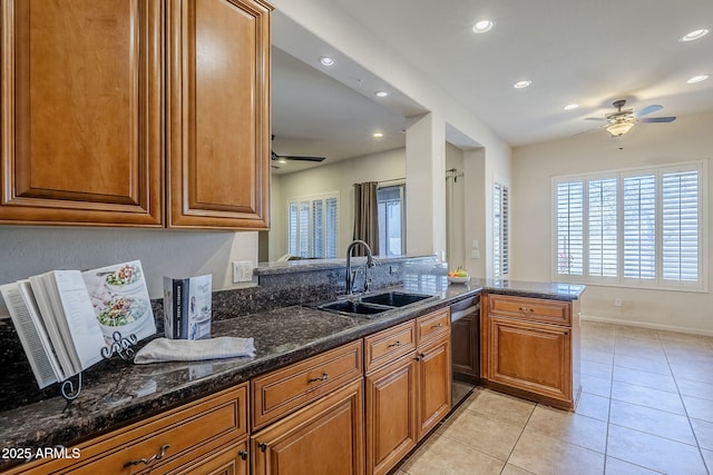 kitchen with sink, black dishwasher, kitchen peninsula, dark stone countertops, and light tile patterned floors