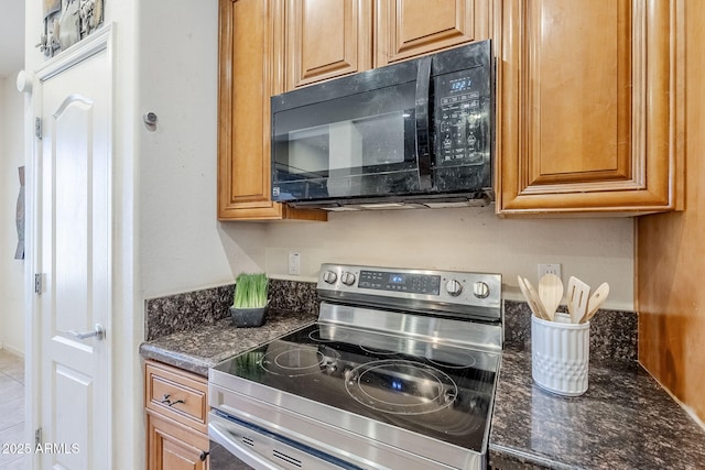 kitchen with dark stone countertops and stainless steel electric range