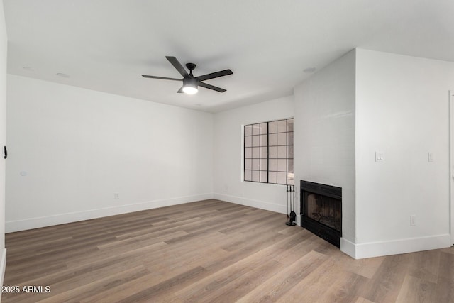 5230 E Brown Rd Unit 114, Mesa, AZ 85205 - unfurnished living room featuring a ceiling fan, a large fireplace, and light wood-type flooring
