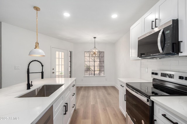 5230 E Brown Rd Unit 114, Mesa, AZ 85205 - kitchen featuring stainless steel appliances, light wood-style floors, backsplash, recessed lighting, and decorative light fixtures