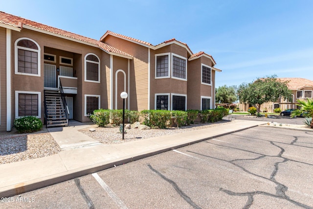 5230 E Brown Rd Unit 114, Mesa, AZ 85205 - view of front facade with uncovered parking, stucco siding, a tiled roof, and stairway