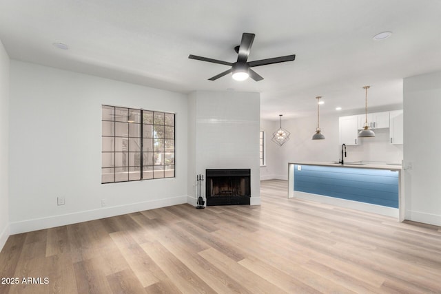5230 E Brown Rd Unit 114, Mesa, AZ 85205 - unfurnished living room with light wood finished floors, a ceiling fan, a fireplace, and recessed lighting