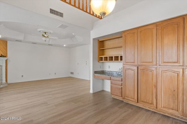 kitchen featuring ceiling fan, light hardwood / wood-style floors, built in desk, and light brown cabinetry